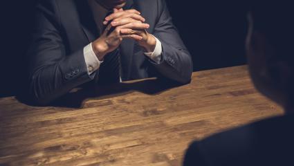 Detective interviewing a subject in a dark room