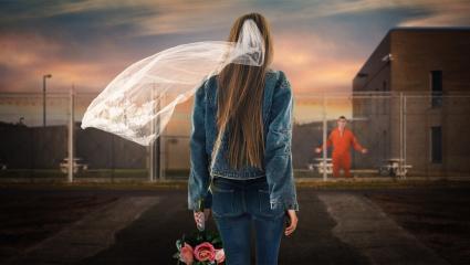 A woman wearing a veil walking towards a prison where a prisoner is waiting for her