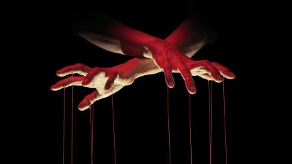 A puppeteer hands ominously control some strings