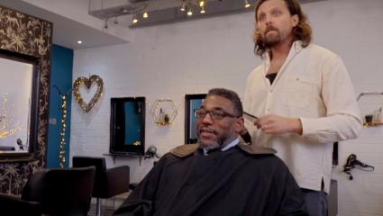 Michael Parris gets his hair cut by James Busby