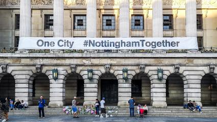 A banner reads 'One City #NottinghamTogether' as floral tributes start to emerge outside The Exchange Arcade in Nottingham