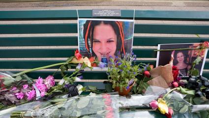 A park bench with photographs of Sophie Lancaster and flowers laid on top