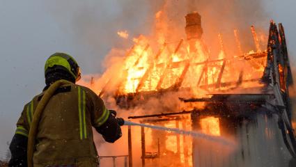 Firefighters battle a house that is engulfed in flames