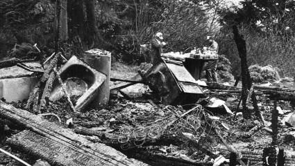 Two FBI agents sift through debris after a home burned to the ground