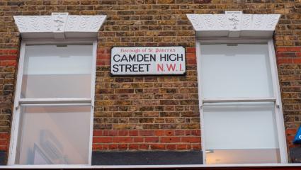 A street sign for 'Camden High Street' on the side of a building
