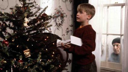 Kevin McCallister (Macaulay Culkin) decorates a Christmas tree while Harry Lime (Joe Pesci) spies on him through the window