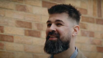 A man with a beard talking about his story