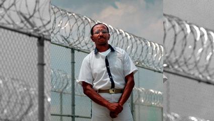 Wayne Williams poses along the fence line of a prison in a 1999 file photo