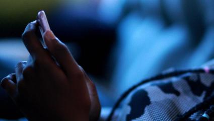 A black teenage girl hold a smartphone in her hands