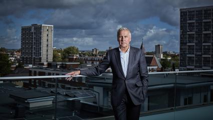 Dermot Murnaghan standing on a rooftop balcony on a dark and stormy day