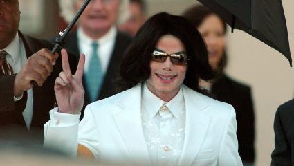 Michael Jackson flashes the 'Peace' sign to crowds of supporters as he arrives at court