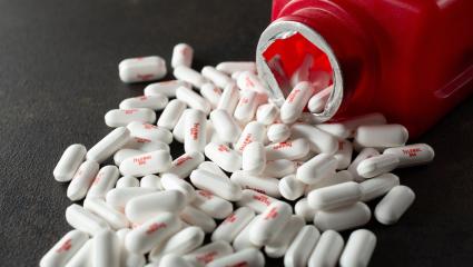 A red Tylenol bottle with pills spilling out