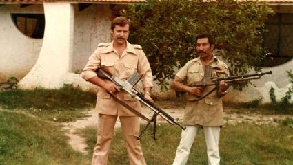 Klaus Barbie (L) holding a large gun during his time in South America