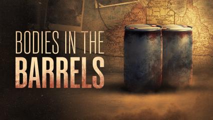 'BODIES IN THE BARRELS' - Two large dirty oil barrels in front of an atlas map of Australia
