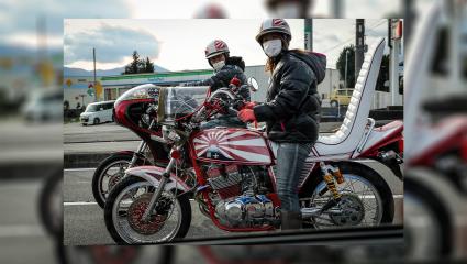 Two Bōsōzoku bikers driving old Japanese bikes in 2016. They are extravagantly decorated