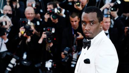 Sean 'Diddy' Combs wearing a white tuxedo on a red carpet