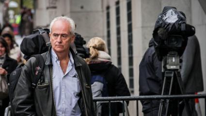 Nick Davies arrives at the Old Bailey court in London - surrounded by news cameras