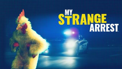 A man in a chicken costume runs away from a police car