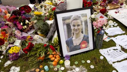 A photo of Jo Cox next to flowers, notes and candles at an impromptu memorial site
