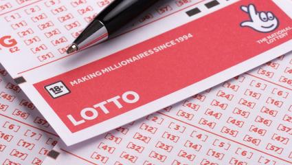 A blank Lotto ticket from the National Lottery with a black pen resting on top of it