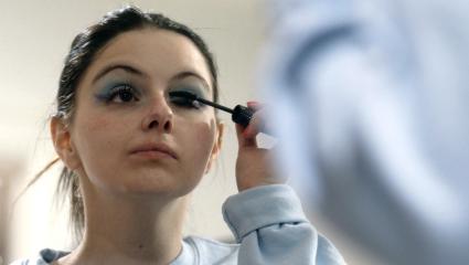 Ariel Winter looks in the mirror as she puts mascara on