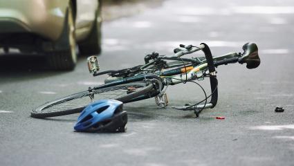 A bike and helmet lying on the road after being hit by a car