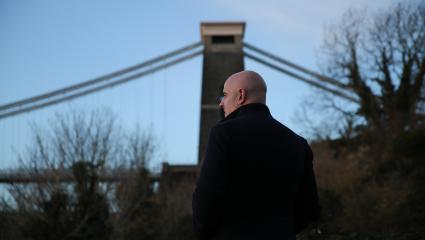 DCI Neil Meade standing in front of the Clifton Suspension Bridge