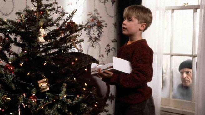 Kevin McCallister (Macaulay Culkin) decorates a Christmas tree while Harry Lime (Joe Pesci) spies on him through the window