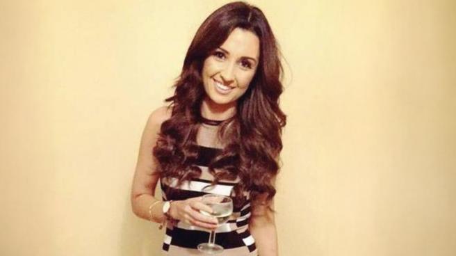 Nadine Lott smiling and holding a glass of wine