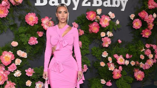 Kim Kardashian wearing a pink dress while posing for photos outside the Baby2Baby annual gala