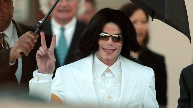 Michael Jackson flashes the 'Peace' sign to crowds of supporters as he arrives at court