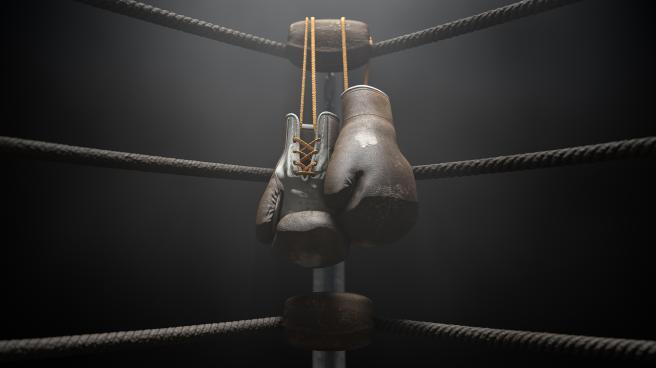 A pair of old boxing gloves hanging on the side of a boxing ring