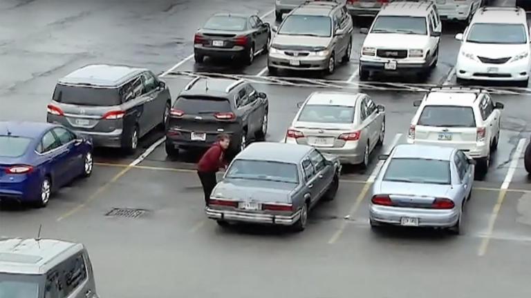 cctv footage of a busy parking lot showing a man getting into a car