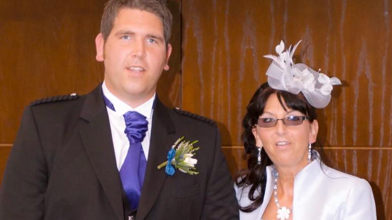 A mother stands next to her son at a wedding