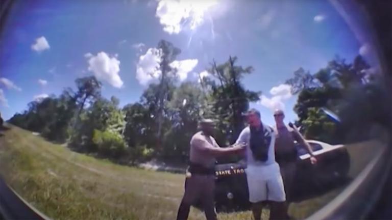 Two policemen lead a suspect away