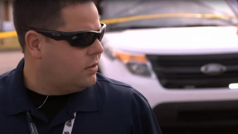 A US police officer wearing sunglasses at the scene of a murder