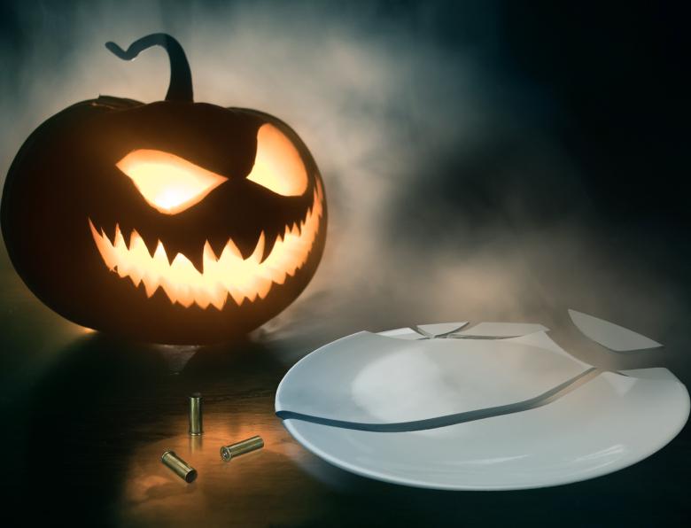 A stock photo of a pumpkin, three bullet cases and a broken plate