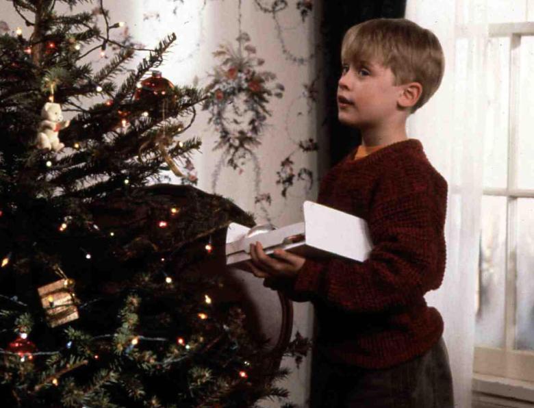Kevin McCallister (Macaulay Culkin) decorates a Christmas tree while Harry Lime (Joe Pesci) spies on him through the window