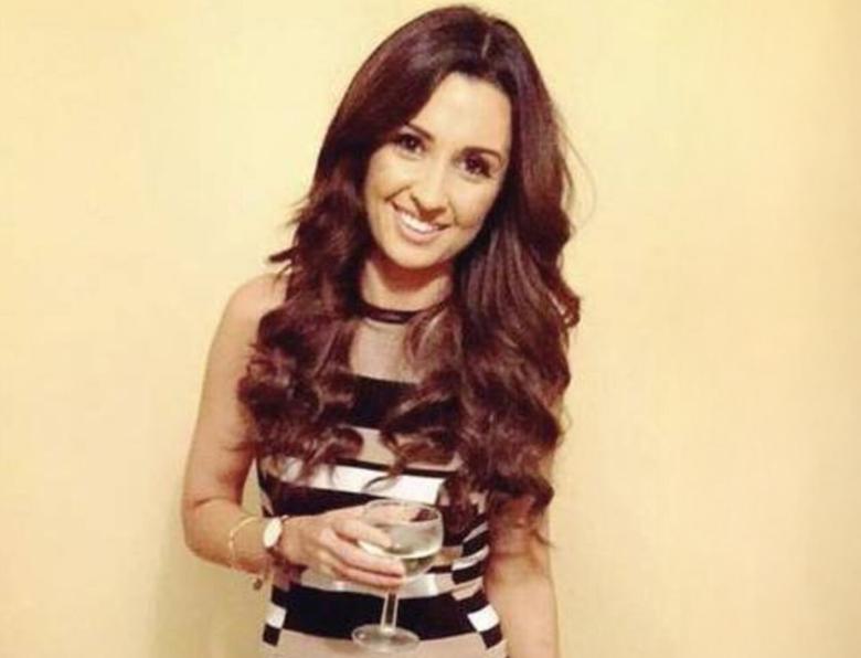 Nadine Lott smiling and holding a glass of wine