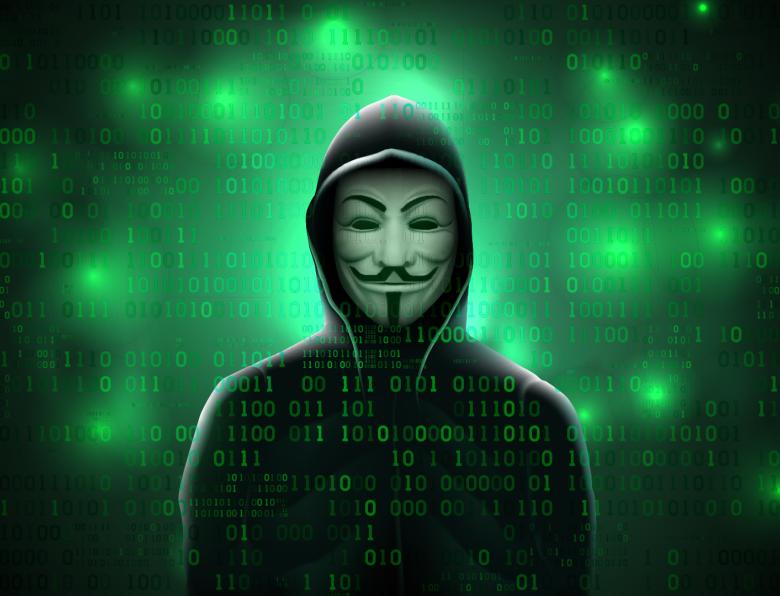 A hooded figure wearing an 'Anonymous' mask on a coded green background
