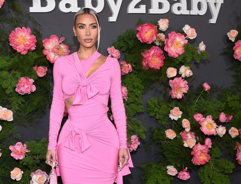 Kim Kardashian wearing a pink dress while posing for photos outside the Baby2Baby annual gala
