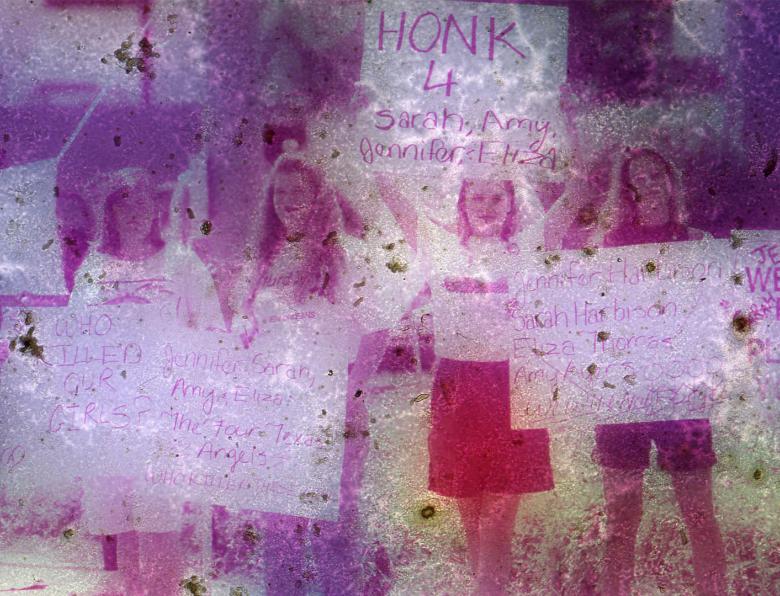 Young women hold up signs of remembrance, and frustration with lack of arrests in the 'Yogurt Shop Murders' case