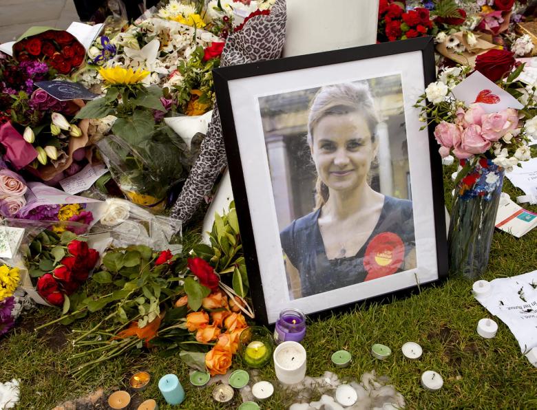 A photo of Jo Cox next to flowers, notes and candles at an impromptu memorial site