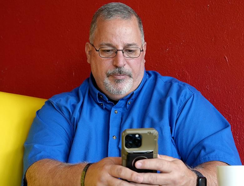 Tony Godwin using a smartphone