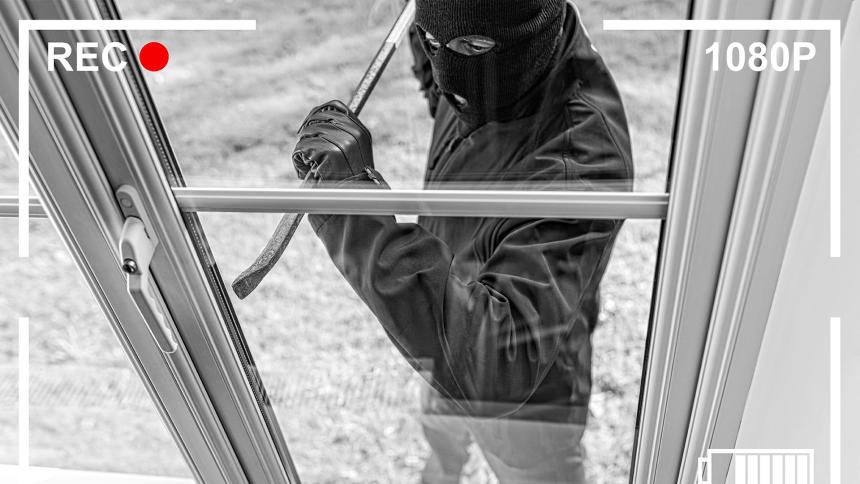 CCTV footage of a burglar breaking through a home window
