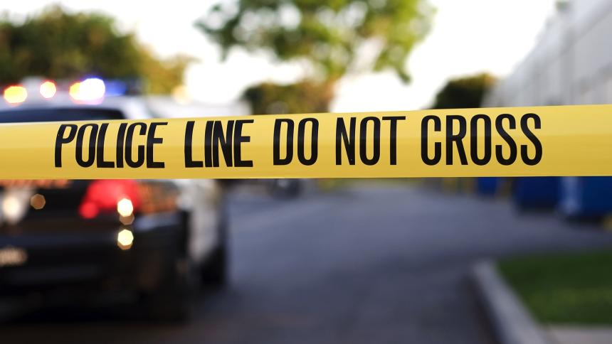 Crime scene tape and a parked police car