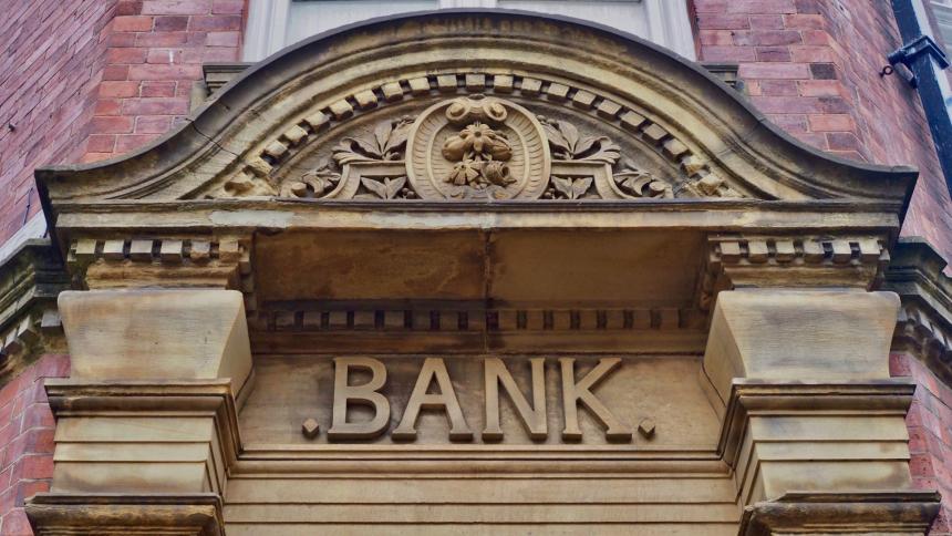 A photograph of a retro stonework bank sign