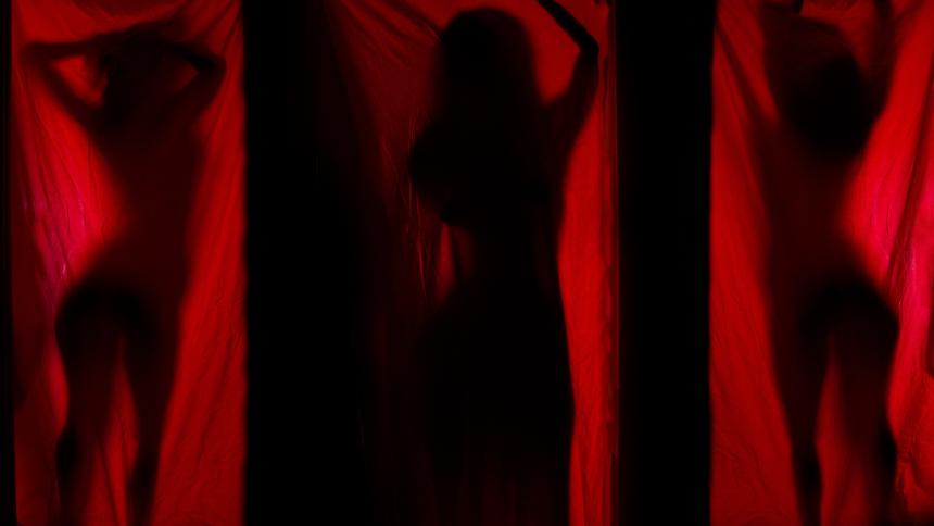 A stock photograph showing multiple woman behind a red curtain.
