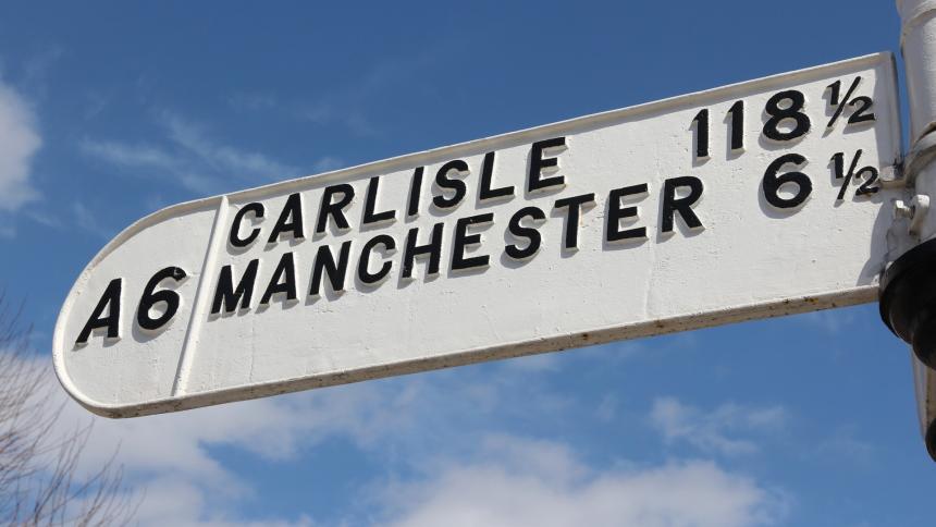 A photograph of a road sign showing distances on the A6 road