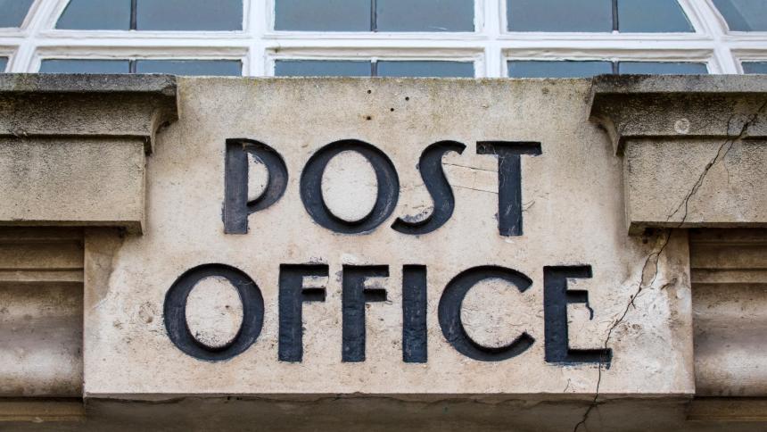 A stock photograph of a Post Office sign.